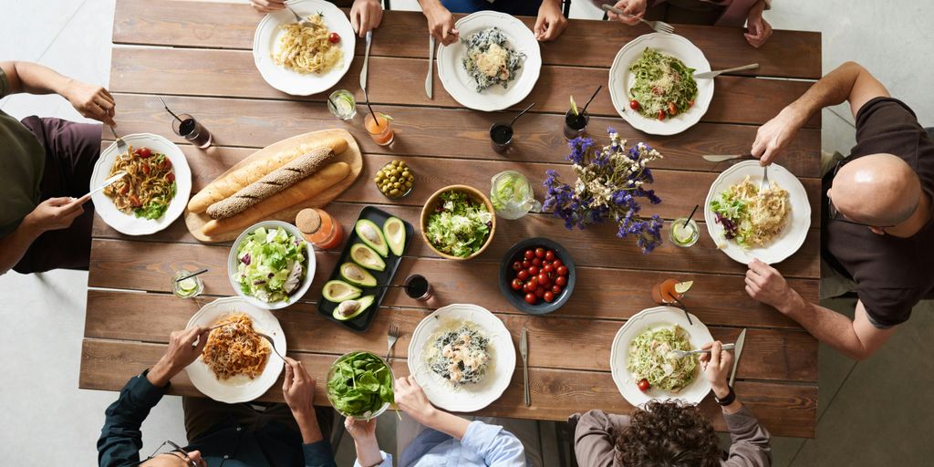 healthy eating concept with diverse group of people sharing a meal full of fruits, vegetables, and whole grains